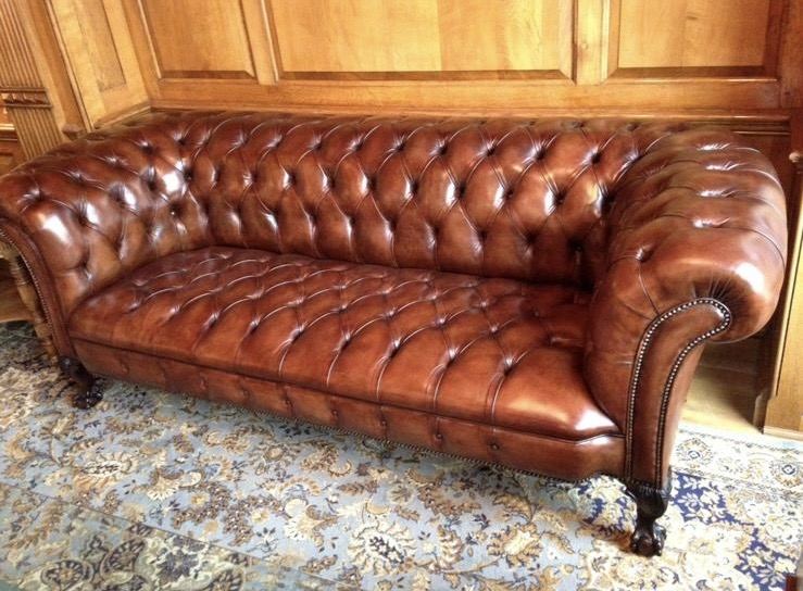 A tan leather Chesterfield sofa after re-leathering